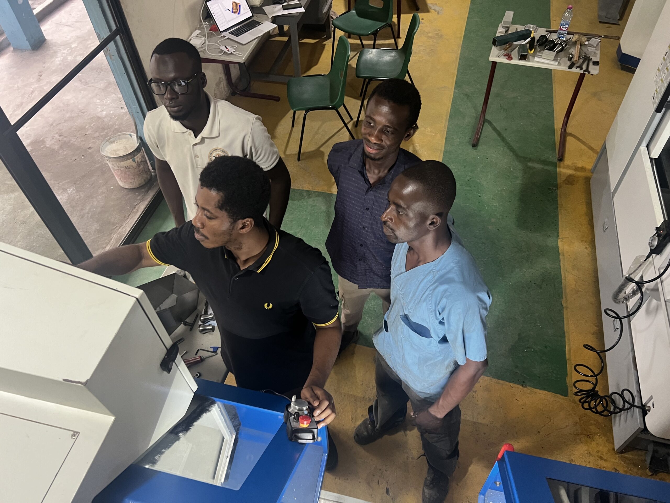 Here Michael, Francis, Rashid and Elliott work on the CNC lathe. 